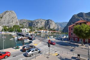 een jachthaven met auto's geparkeerd naast het water bij Apartment Mate in Omiš