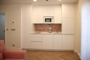 kuchnia z białymi szafkami i mikrofalówką w obiekcie Apartamentos La Quinta w mieście Burgos +33 zdjęcia