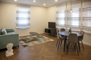 sala de estar con mesa, sillas y sofá en Apartamentos La Quinta, en Burgos