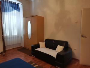a living room with a black leather couch and a window at Apartment Lucky Luke in Pula