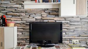 un televisor sentado en una mesa frente a una pared de piedra en Apartamento Bella Almagro, en Almagro