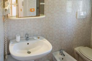 a bathroom with a sink and a toilet and a mirror at B&B Sara in Santa Maria al Bagno