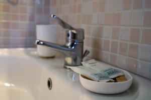 a bathroom sink with a bowl of toothpaste at B&B Sara in Santa Maria al Bagno
