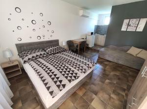 a bedroom with a large bed and a couch at Vasti Apartman in Siófok
