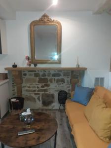 een woonkamer met een bank en een tafel met een spiegel bij Trévoux: loft ravissant avec terrasse in Trévoux