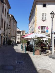 a street with tables and umbrellas in a city at Trévoux: loft ravissant avec terrasse in Trévoux