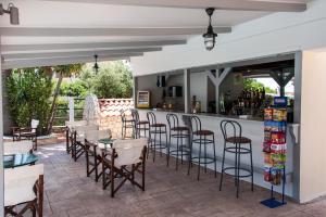 a patio with a bar with chairs and tables at Bozikis Palace Hotel in Laganas