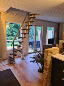 uma sala de estar com uma escada em espiral numa casa em Pinebo Palace Guesthouse em Ulricehamn