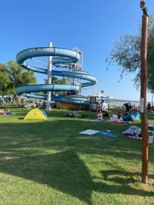 a group of people in a park with a water slide at Jasmin Apartment House in Vonyarcvashegy