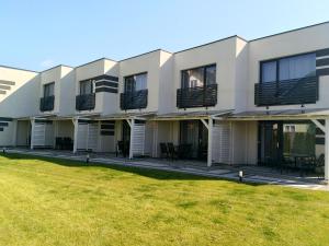 a building with a lawn in front of it at Over Lake-domki,apartamenty in Mielno