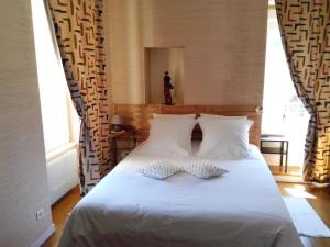 a bedroom with a white bed with two pillows at Izella in Douarnenez