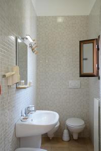 a white bathroom with a sink and a toilet at B&B Sara in Santa Maria al Bagno