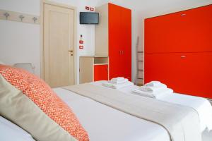 a bedroom with red cabinets and a white bed at B&B Sara in Santa Maria al Bagno