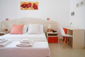 a bedroom with a white bed with towels on it at B&B Sara in Santa Maria al Bagno
