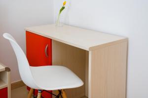 a white desk with a white chair and a vase at B&B Sara in Santa Maria al Bagno