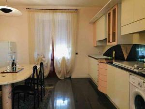 eine Küche mit einem Tisch, einem Waschbecken und einem Fenster in der Unterkunft Villa Cycas in Casal Taulero