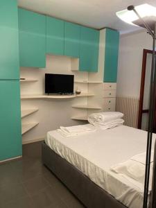a bedroom with a bed and a tv and blue cabinets at Villa Cycas in Casal Taulero