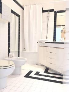 a white bathroom with a toilet and a sink at Villa Cycas in Casal Taulero