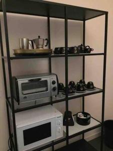 ein Regal mit einer Mikrowelle und einem Toaster in der Unterkunft Villa Cycas in Casal Taulero + 20 Fotos