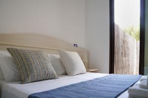 a bedroom with a bed with white sheets and pillows at B&B Sara in Santa Maria al Bagno