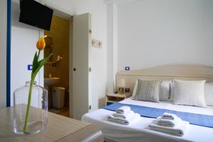 a bedroom with a bed and a vase with a flower on a table at B&B Sara in Santa Maria al Bagno
