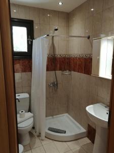La salle de bains est pourvue d'une douche, de toilettes et d'un lavabo. dans l'établissement OASIS APARTMENTS, à Livadia