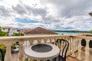 balcone con tavolo, sedie e vista sull'acqua di Apartments Marina a Trogir