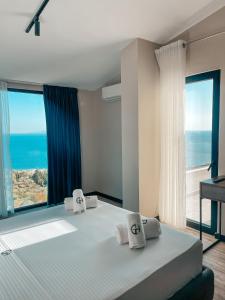 a bedroom with a bed with a view of the ocean at Gogo's Boutique Hotel in Dhërmi
