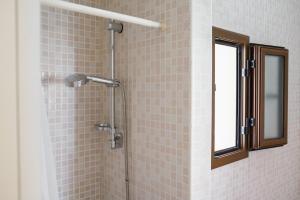 a shower in a bathroom with pink tile at B&B Sara in Santa Maria al Bagno