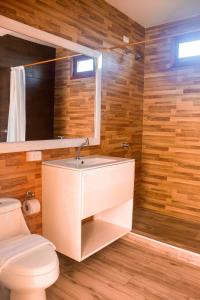 a bathroom with a white sink and a toilet at Galápagos Isabela Hotel Loja in Puerto Villamil