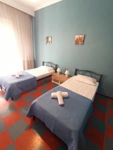 two beds in a room with blue walls at Heart of the Kavala in Kavála