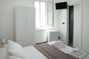 a white bedroom with a bed with towels on it at B&B Sara in Santa Maria al Bagno