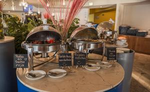 a buffet with several pots and pans on a table at Holiday Inn Resort Acapulco, an IHG Hotel in Acapulco