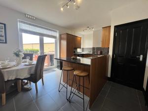 a kitchen with a table and a dining room at Modern mid terrace villa, Royston, Barnsley in Royston