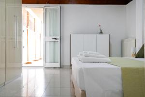 a white room with a bed with towels on it at B&B Sara in Santa Maria al Bagno