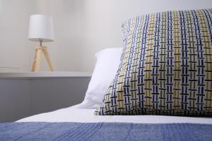 a bed with a pillow on it with a lamp at B&B Sara in Santa Maria al Bagno