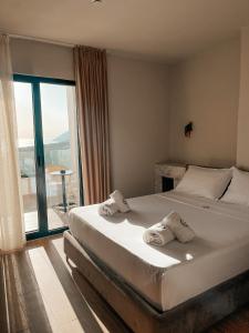 a bedroom with a large bed and a large window at Gogo's Boutique Hotel in Dhërmi