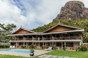 un complexe avec une montagne en arrière-plan dans l'établissement Boutik Le Morne Holiday Apartments, au Morne