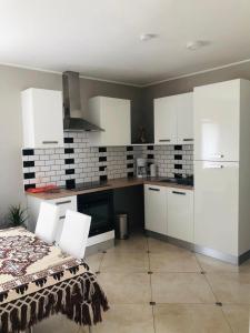 a kitchen with white cabinets and white appliances at Les Gites du Valjoly 2 in Touvent