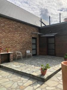 a patio with two chairs and a brick building at Les Gites du Valjoly 2 in Touvent