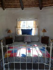 Sheeprun Farmstay في Maclear: سرير في غرفة نوم مع نافذة وإطار سرير