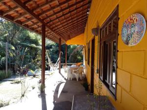 a yellow building with awning and a patio at Casa Beira Rio - Sítio Terra Surya in Lumiar