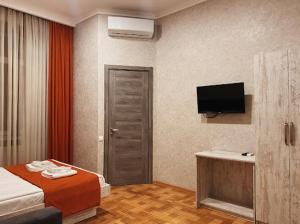 una camera con letto e TV a schermo piatto di Apart-Hotel Shell a Tbilisi City