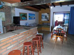 a bar with stools and a table in a room at Morada d'Omar 4 Ilhas in Bombinhas