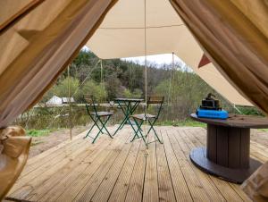 a tent with chairs and a table in it at Naturally Glamping in Kingsteignton