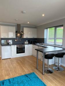 uma grande cozinha com uma mesa e cadeiras em Rammal Lodge - Entire home, self catering apartment in Inverness em Inverness
