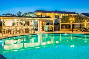 a swimming pool in front of a house at Bozikis Palace Hotel in Laganas