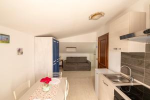 a kitchen with a table with a vase of flowers on it at Casa Vacanze La Magnolia in Viterbo