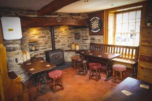 a restaurant with a table and chairs and a fireplace at The Dudley Arms in Llandrillo