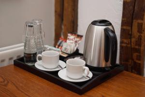 a coffee maker and two cups on a tray on a table at The Dudley Arms in Llandrillo